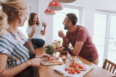Sarışın bayan yemek pişirme ve aile ile vakit geçirmek