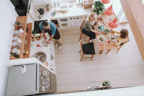 Liebender Ehemann und Vater kocht Abendessen für seine Familie — Stockfoto