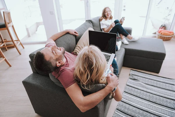 Milující rodiče s laptopem a jejich dcera tráví čas společně doma — Stock fotografie