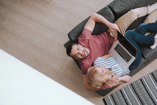 Красивая пара отдыхает и использует ноутбук дома — стоковое фото
