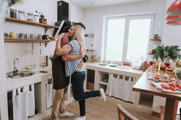 Vackra kärleksfulla par kramar i köket hemma — Stockfoto