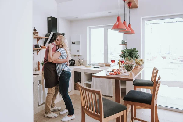 Hermosa pareja enamorada abrazándose en la cocina en casa —  Fotos de Stock