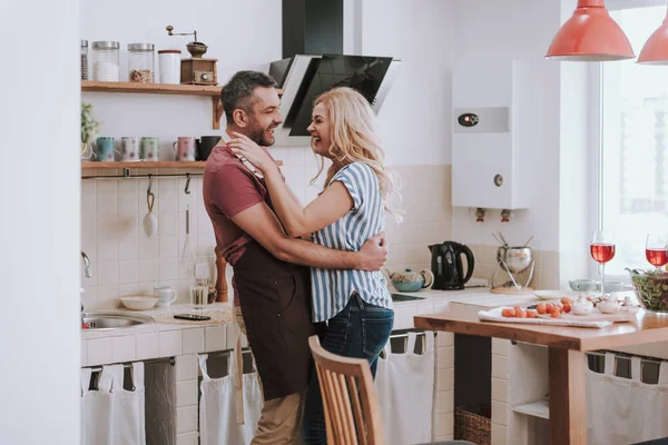 Счастливая любящая пара обнимается дома на кухне — стоковое фото