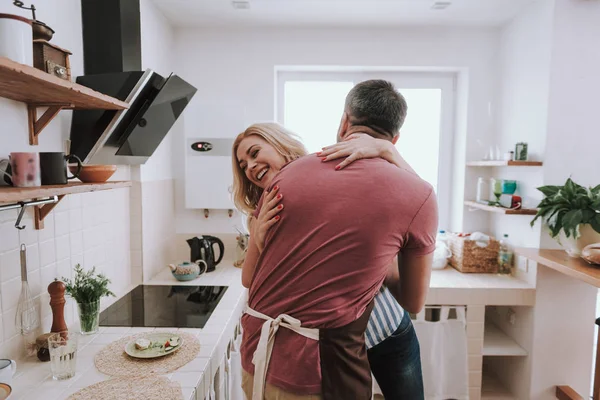 Schönes glückliches Paar umarmt und lacht in der Küche — Stockfoto