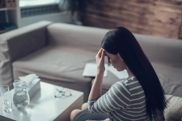 Hög vinkel av deprimerad kvinna som håller huvudet i händerna inomhus — Stockfoto
