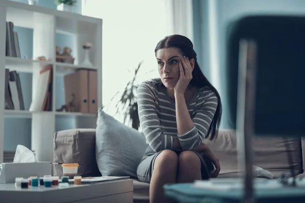 Mujer infeliz cansada mirando a un lado en el gabinete —  Fotos de Stock