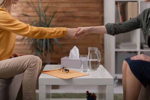 Psicólogo y paciente estrechándose la mano sobre la mesa en el interior — Foto de Stock