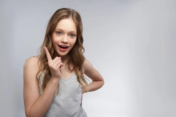 Schönes Teenie-Mädchen im Tank-Top vor grau-weißem Hintergrund — Stockfoto