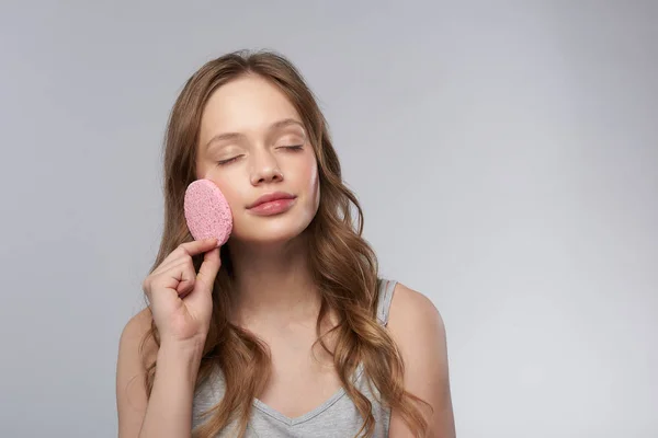 Charmantes Teenie-Mädchen mit geschlossenen Augen mit rosa Reinigungsschwamm — Stockfoto