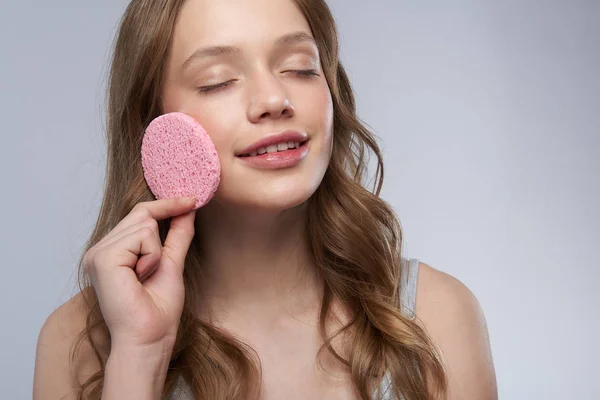 Nettes Teenie-Mädchen mit geschlossenen Augen mit rosa Reinigungsschwamm — Stockfoto