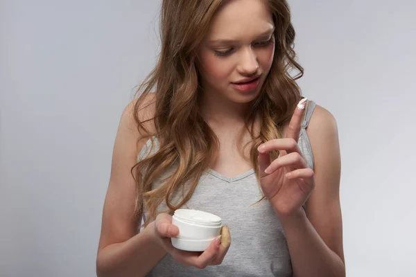 Schöne Teen-Mädchen in grauen Tank-Top-Test Hautpflege-Produkt — Stockfoto