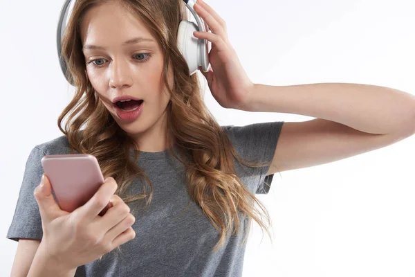 Encantadora chica adolescente en auriculares inalámbricos con teléfono celular — Foto de Stock