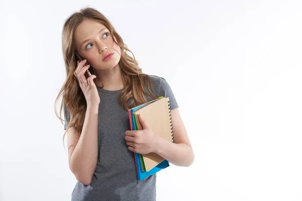 Nettes Teenie-Mädchen mit Notizbüchern im Handy-Gespräch — Stockfoto