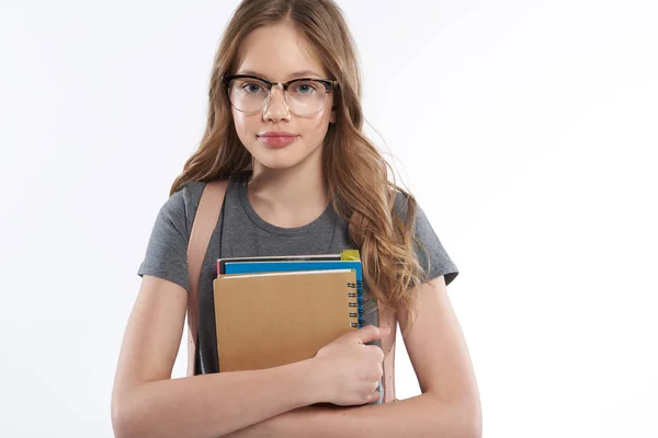 Gyönyörű tini lány szemüveg gazdaság spirál notebook és tankönyvek — Stock Fotó