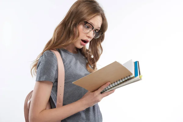 Döbbenten tini lány szürke póló gazdaság spirál notebook — Stock Fotó