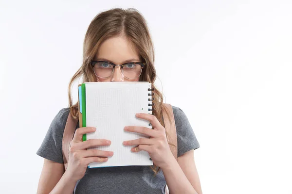 Bájos tini lány szemüveg kiterjedő arc spirális notebook — Stock Fotó
