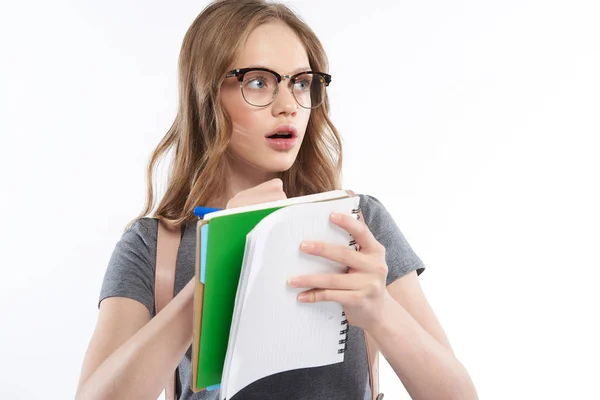 Meghökkent tini lány szemüveg írásban spirális notebook — Stock Fotó