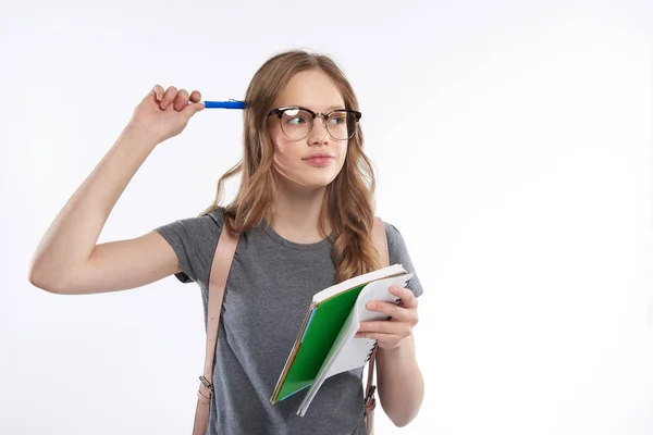 Menina adolescente encantadora em óculos coçar a cabeça com caneta e pensar — Fotografia de Stock