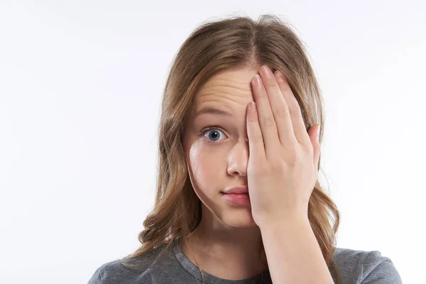 Betäubte Teenagerin bedeckt Hälfte ihres Gesichts mit Hand — Stockfoto