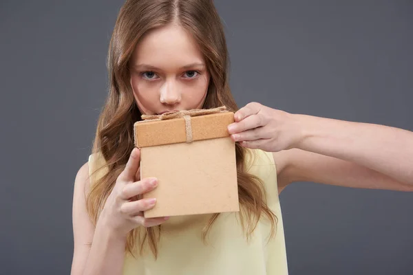 Schöne Teen-Mädchen mit braunen Haaren hält niedlichen Geschenkkarton — Stockfoto