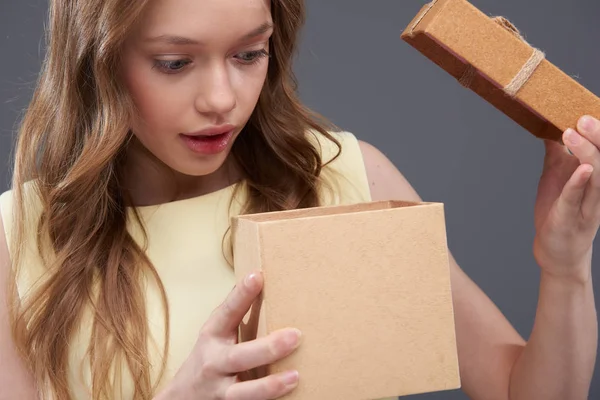 Lovely teen girl with long brown hair opening gift box — Stock Photo, Image