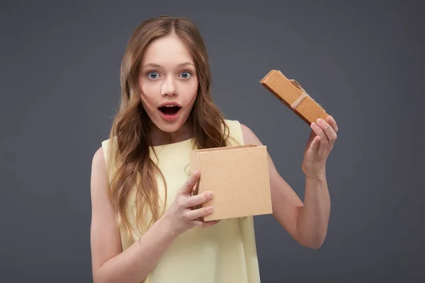 惊讶 的 少女 与 长 棕色 头发 拿着 打开 的 礼品 盒 — 图库照片