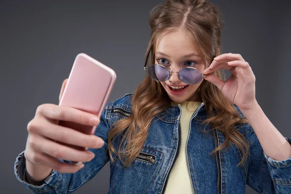 Adolescente joyeuse avec une coiffure élégante faisant selfie — Photo