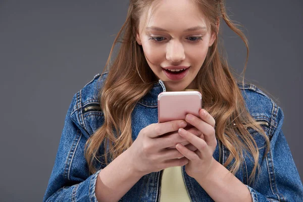 Belle adolescente aux cheveux bruns utilisant un téléphone portable — Photo