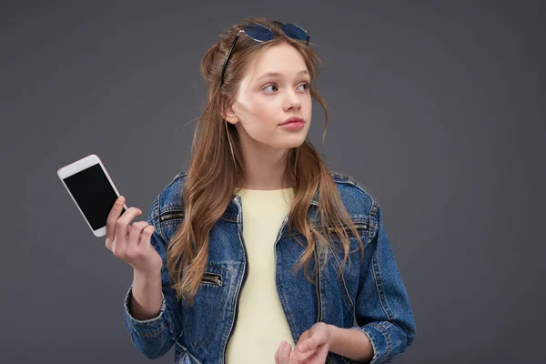 Mooie tiener meisje in Jean jas houden moderne mobiele telefoon — Stockfoto