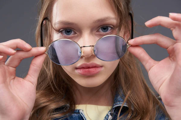 Hermosa chica adolescente quitándose gafas redondas azules — Foto de Stock