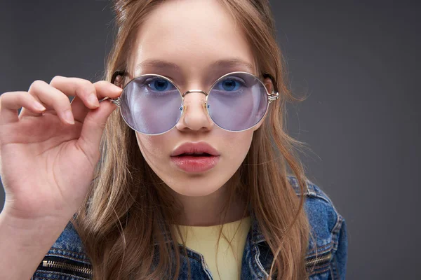 Hermosa chica adolescente tocando montura de gafas redondas azules — Foto de Stock