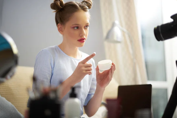 Cute teen girl making vlog and showing how to use cosmetic cream — Stock Photo, Image