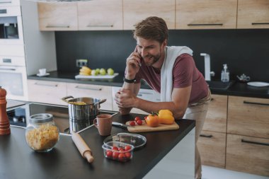 Gülümseyen adam akşam yemeğiiçin arkadaşlarını davet