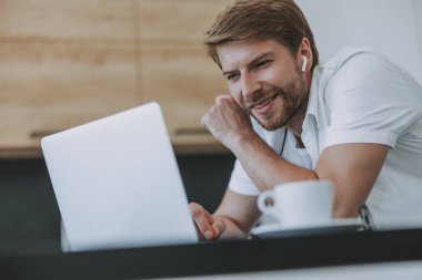 Dizüstü bilgisayarında mesaj okuyan genç adam