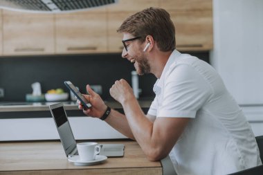 Arkadaşından bir mesaj okurken gülen adam