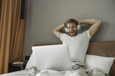 Yatağında film izleyen genç adam