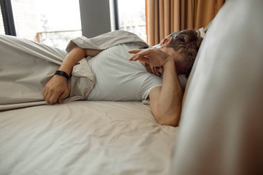 Yatağında tek başına yatan uykulu adam