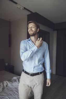 Handsome man putting on his favorite scent