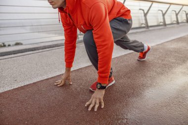 Genç erkek sprinter koşmaya hazırlanıyor