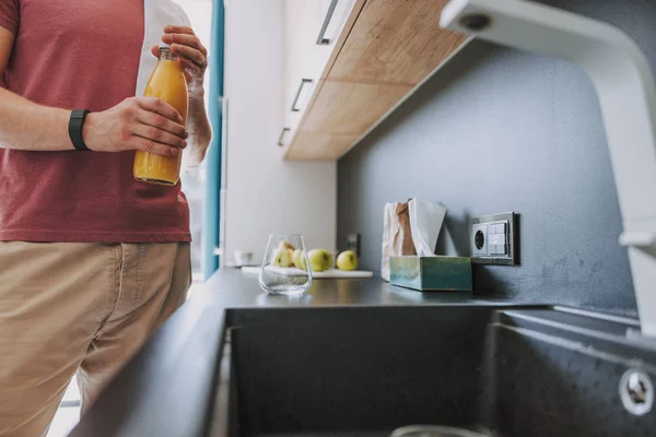 Homem vai derramar um pouco de suco no copo — Fotografia de Stock