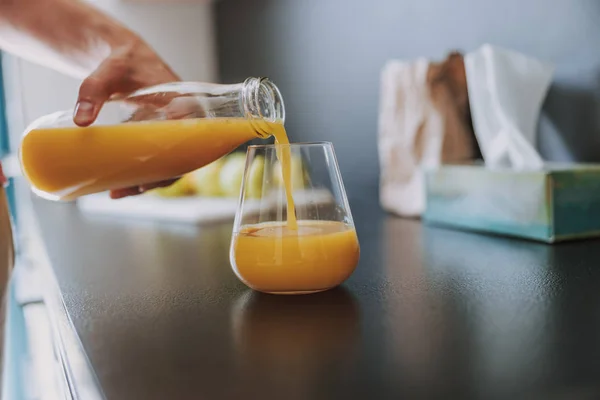 Άνθρωπος που ρίχνει χυμό πορτοκάλι στο γυαλί — Φωτογραφία Αρχείου