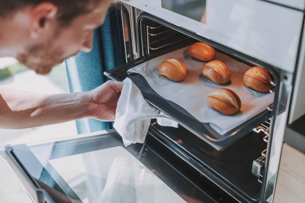 Feliz hombre sacando su pastel del horno — Foto de Stock