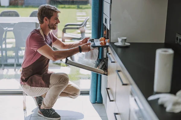 Interested man taking his prepared baked foods — Stock Photo, Image