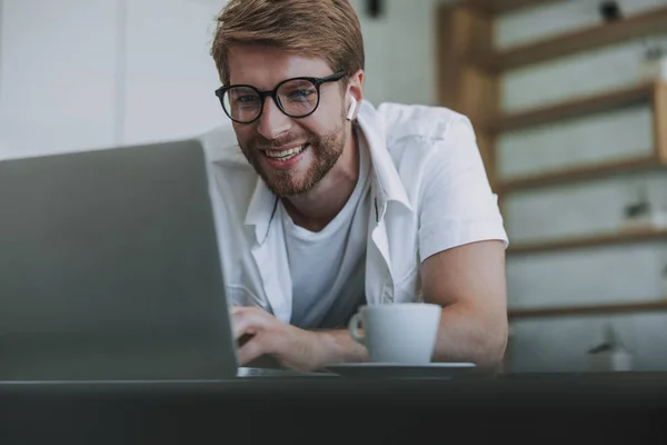 Lächelnder Mann im Gespräch mit seinem Freund auf seinem Laptop — Stockfoto