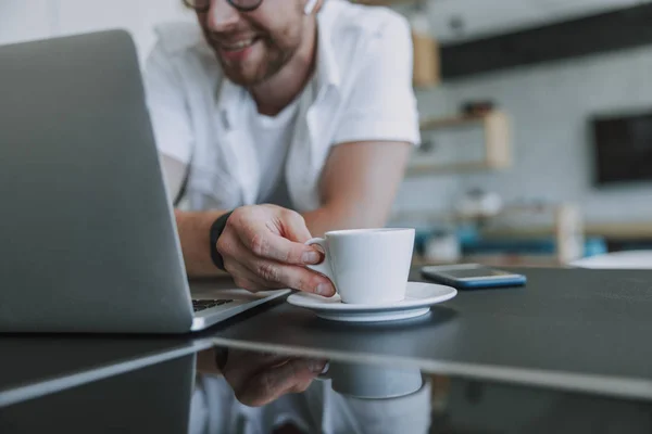 Mutlu adam kahve içiyor ve evde çalışıyor. — Stok fotoğraf