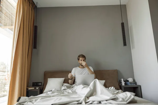 Ο άνθρωπος που επηρεάζεται από το κρύο κάθεται στο κρεβάτι του — Φωτογραφία Αρχείου