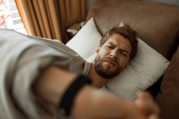 Grumpy człowiek budzi się w jego przytulnym łóżku — Zdjęcie stockowe