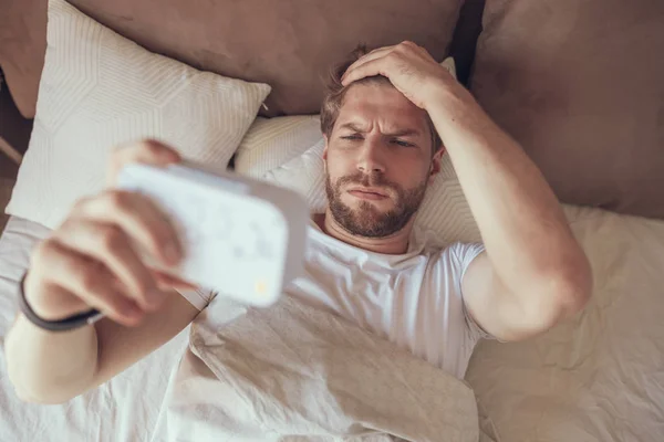 Hombre somnoliento averiguando qué hora es — Foto de Stock