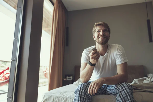 Happy man watching tv before getting up — Stockfoto