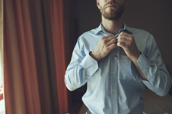 Ernsthafter Mann zieht Kleidung an, um zur Arbeit zu gehen — Stockfoto